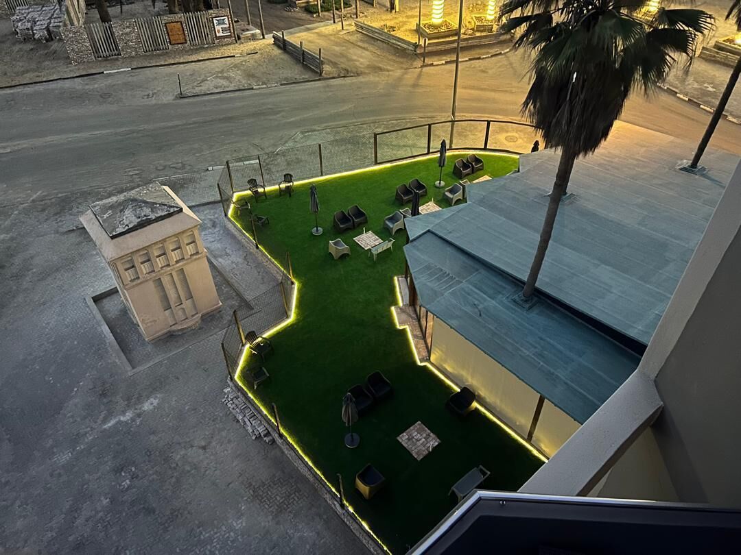 An aerial view of a rooftop garden with seating areas and a small building structure.