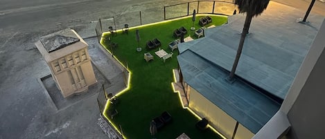 An aerial view of a rooftop garden with seating areas and a small building structure.