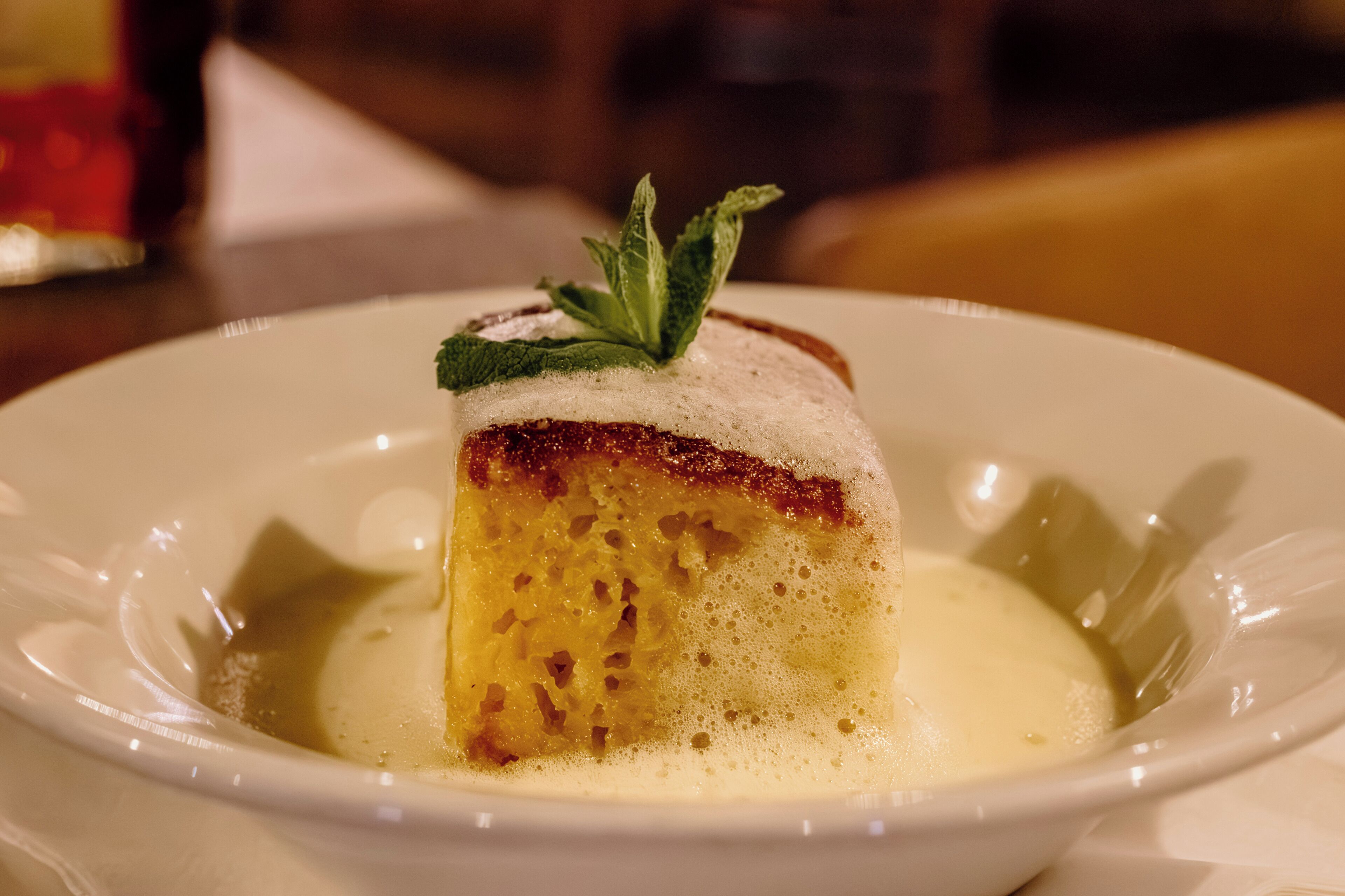 A dessert on a white plate with a mint garnish.