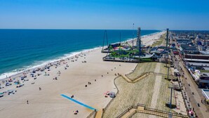 An aerial view of a beach with a roller coaster, a boardwalk, and a sandy shore. - Hammock Inn & Suites - Jersey Shore (Seaside Heights)