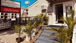 A hotel entrance with a 'Welcome' sign, a satellite dish, and potted plants. - Hammock Inn & Suites - Jersey Shore (Seaside Heights)
