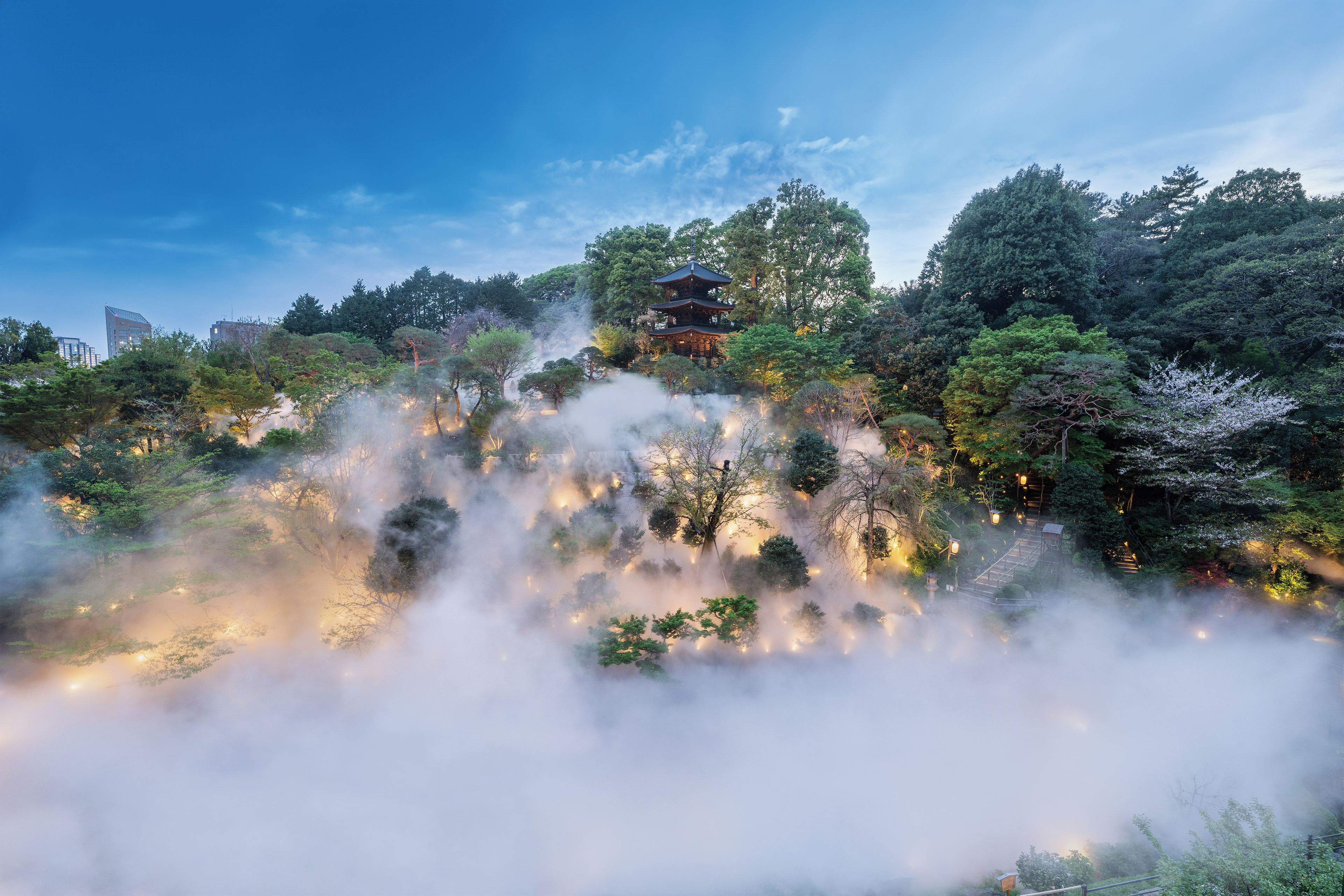 Um pagode japonês tradicional envolto em vegetação exuberante e névoa.