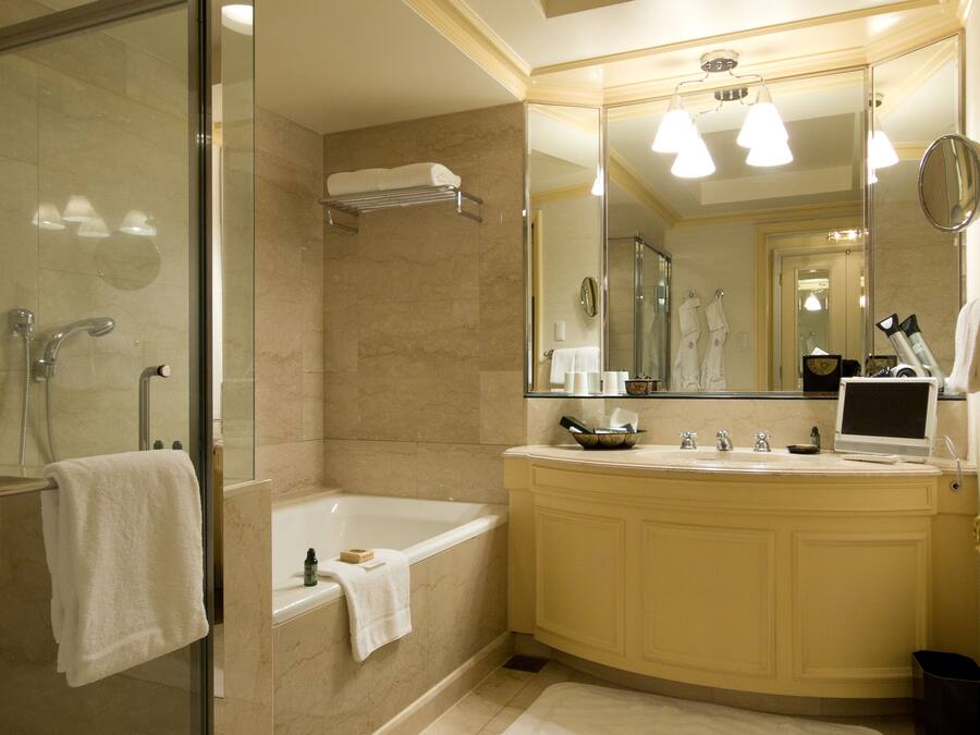 Une salle de bain moderne avec une douche à parois de verre, une baignoire, un meuble-lavabo avec un miroir et un évier.