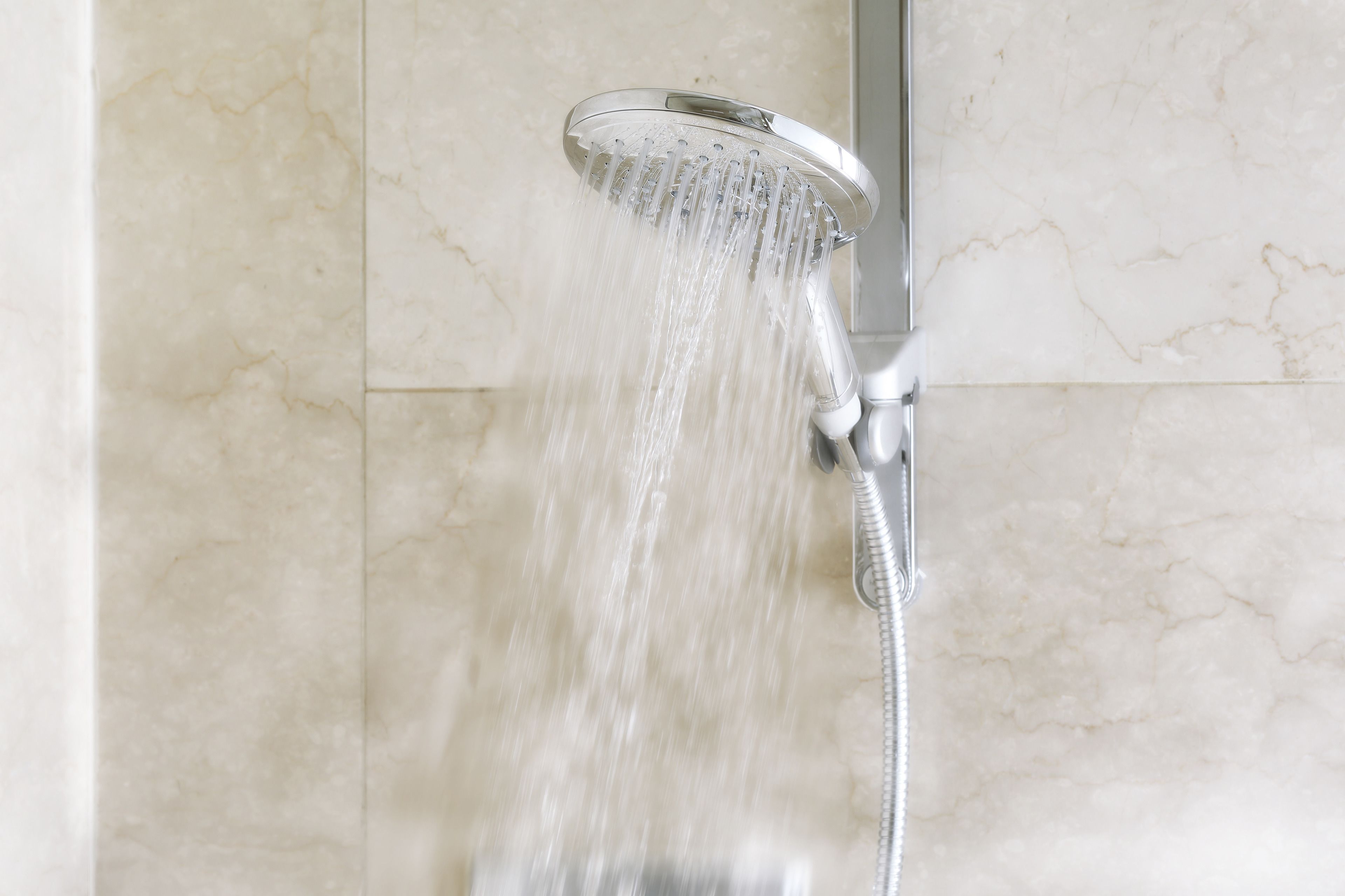 A showerhead with water flowing from it.