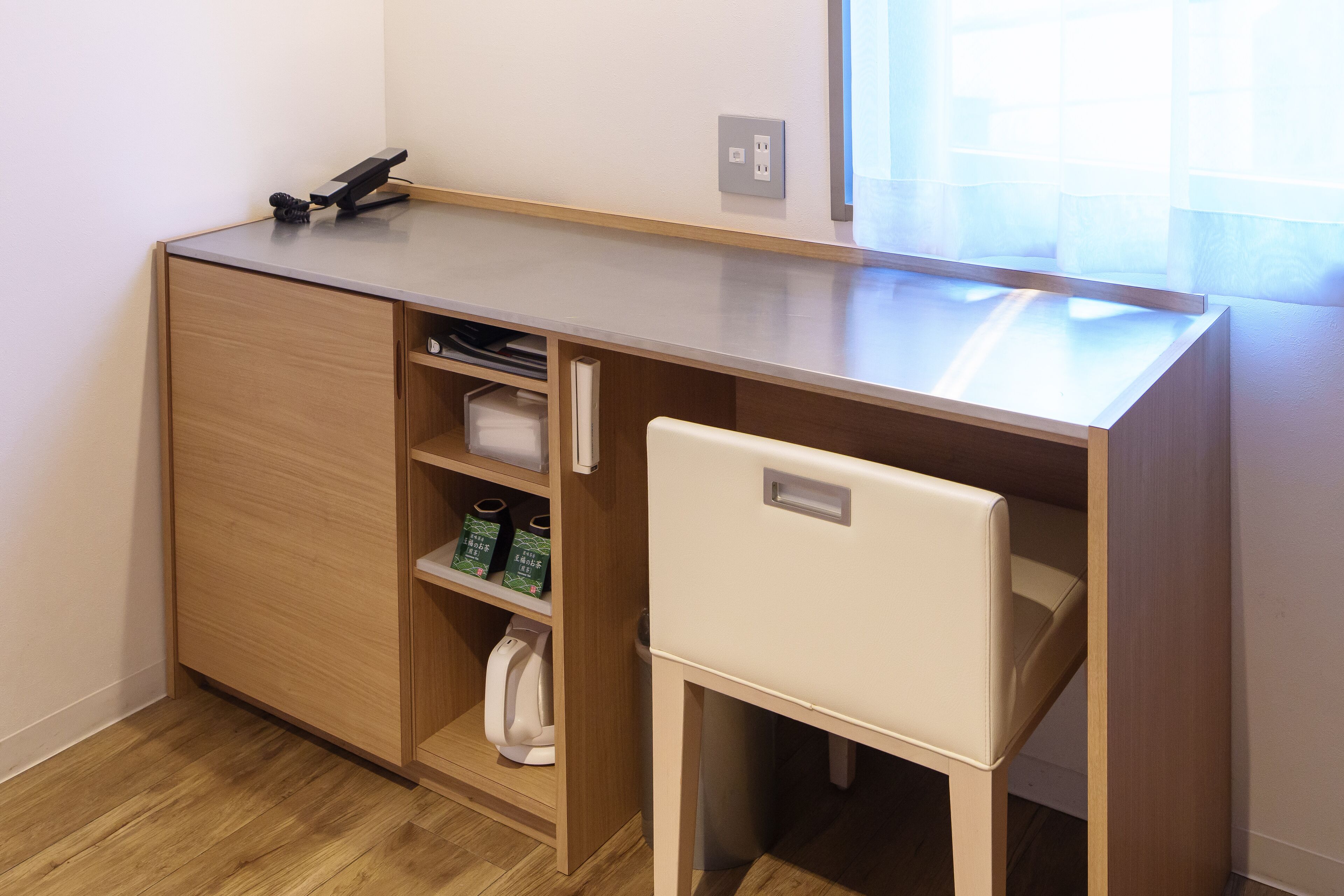 Un espacio de trabajo pequeño y funcional, con escritorio, silla y almacenamiento integrado.