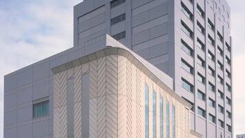 A modern hotel with a large entrance and a tall building adjacent to it.