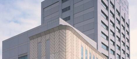 Un moderno edificio de hotel con una entrada destacada y una estructura alta.