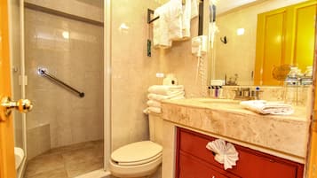 A bathroom with a shower, toilet, and vanity with a mirror.