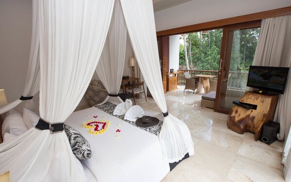 A bedroom with a four-poster bed, a television, and a balcony with outdoor furniture.