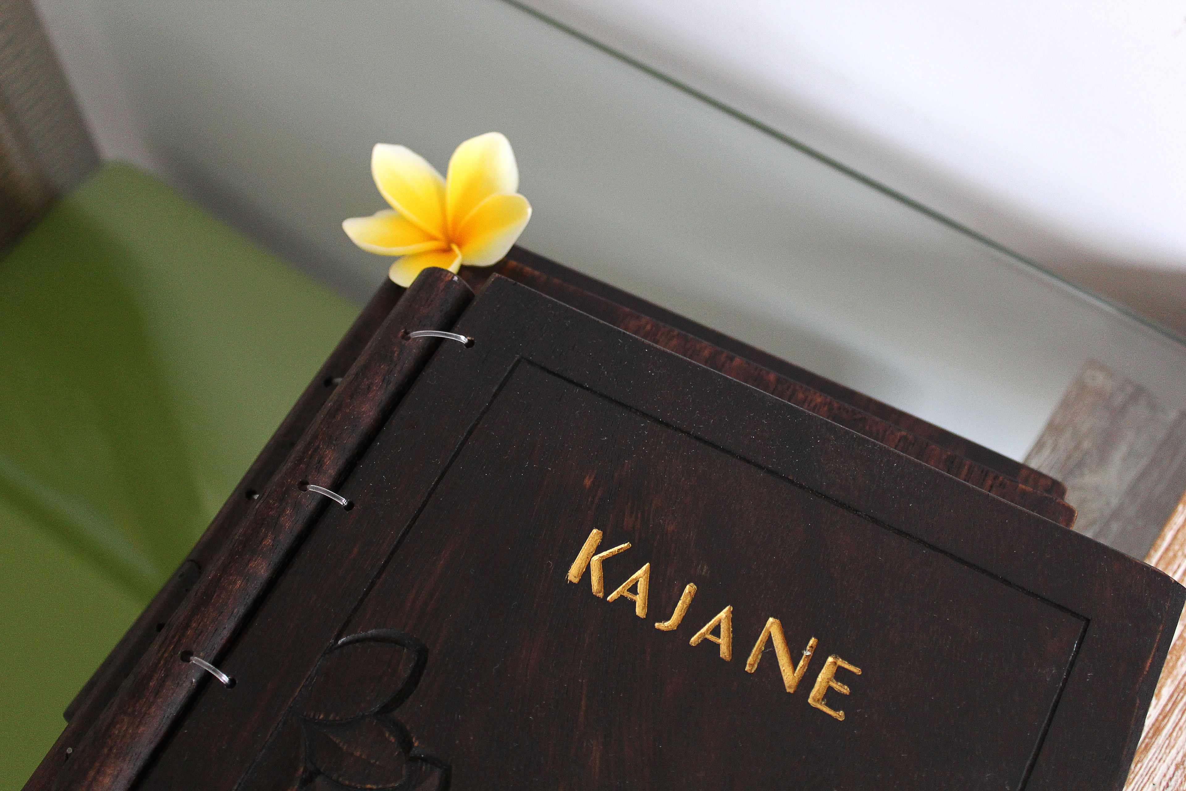 A dark wooden box with the word "KAJANE" embossed on it.