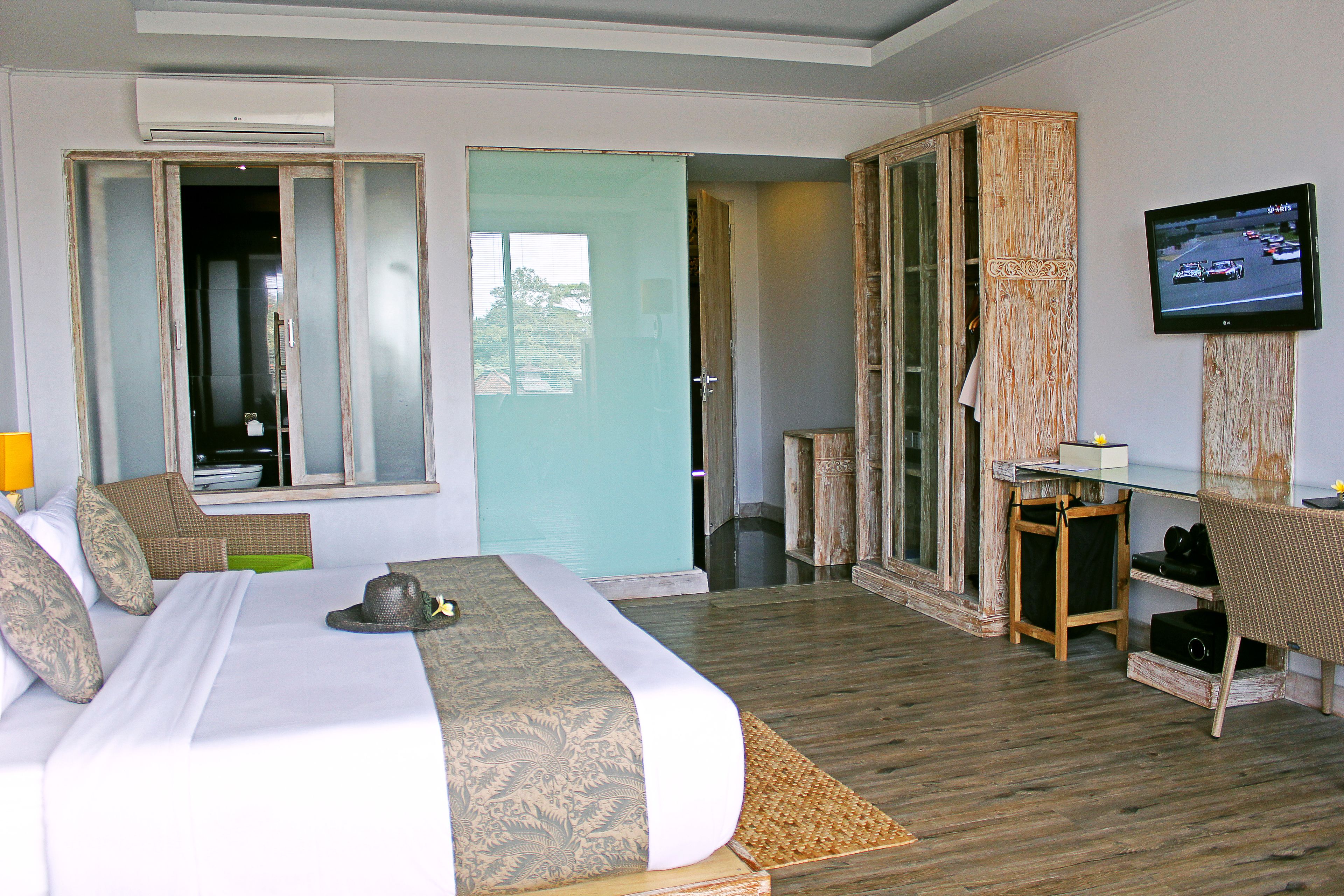 A hotel room with a bed, a television, a desk, and a wardrobe.