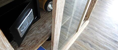 A wooden floor, a scale, and a black device with a keypad.