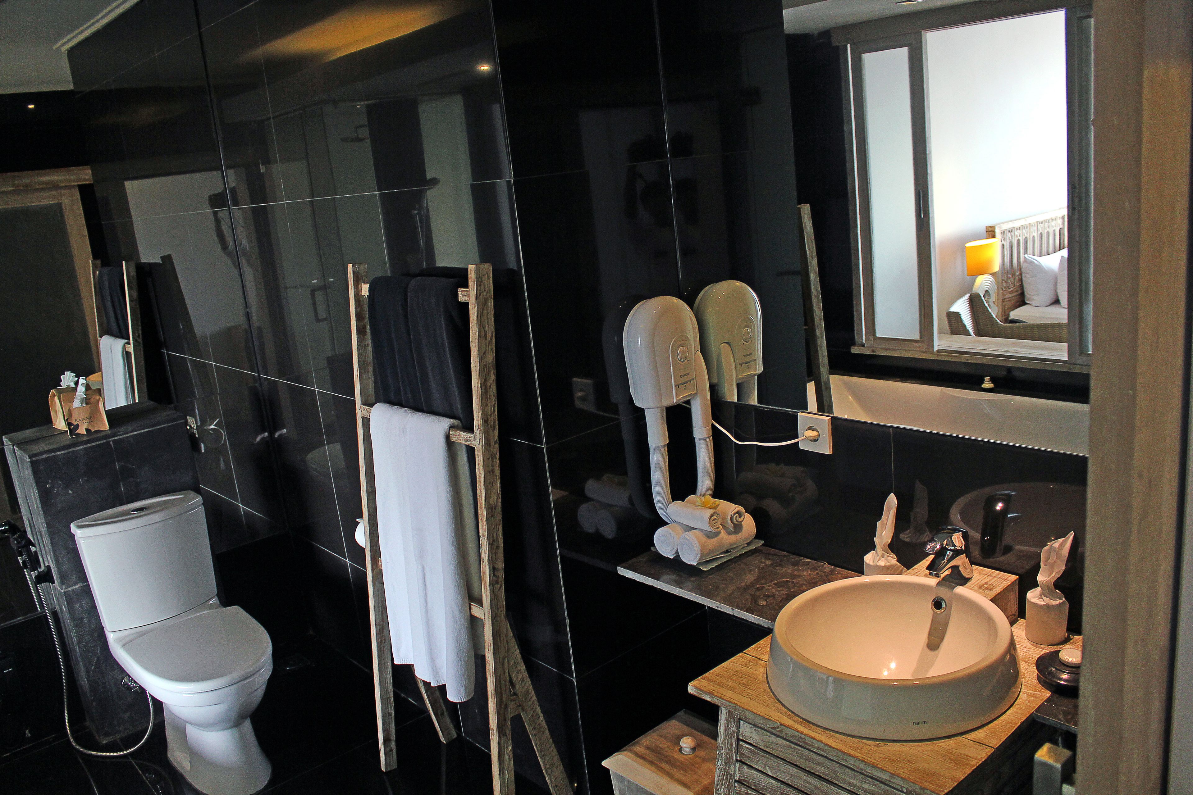 Une salle de bain moderne avec des toilettes, un lavabo et un miroir.