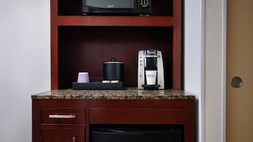 A kitchenette with a microwave, coffee maker, and a small refrigerator.