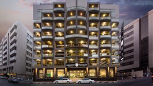 Un hôtel à plusieurs étages doté d’un atrium central, de balcons à chaque étage et d’une enseigne bien visible indiquant « Savoy Central ».