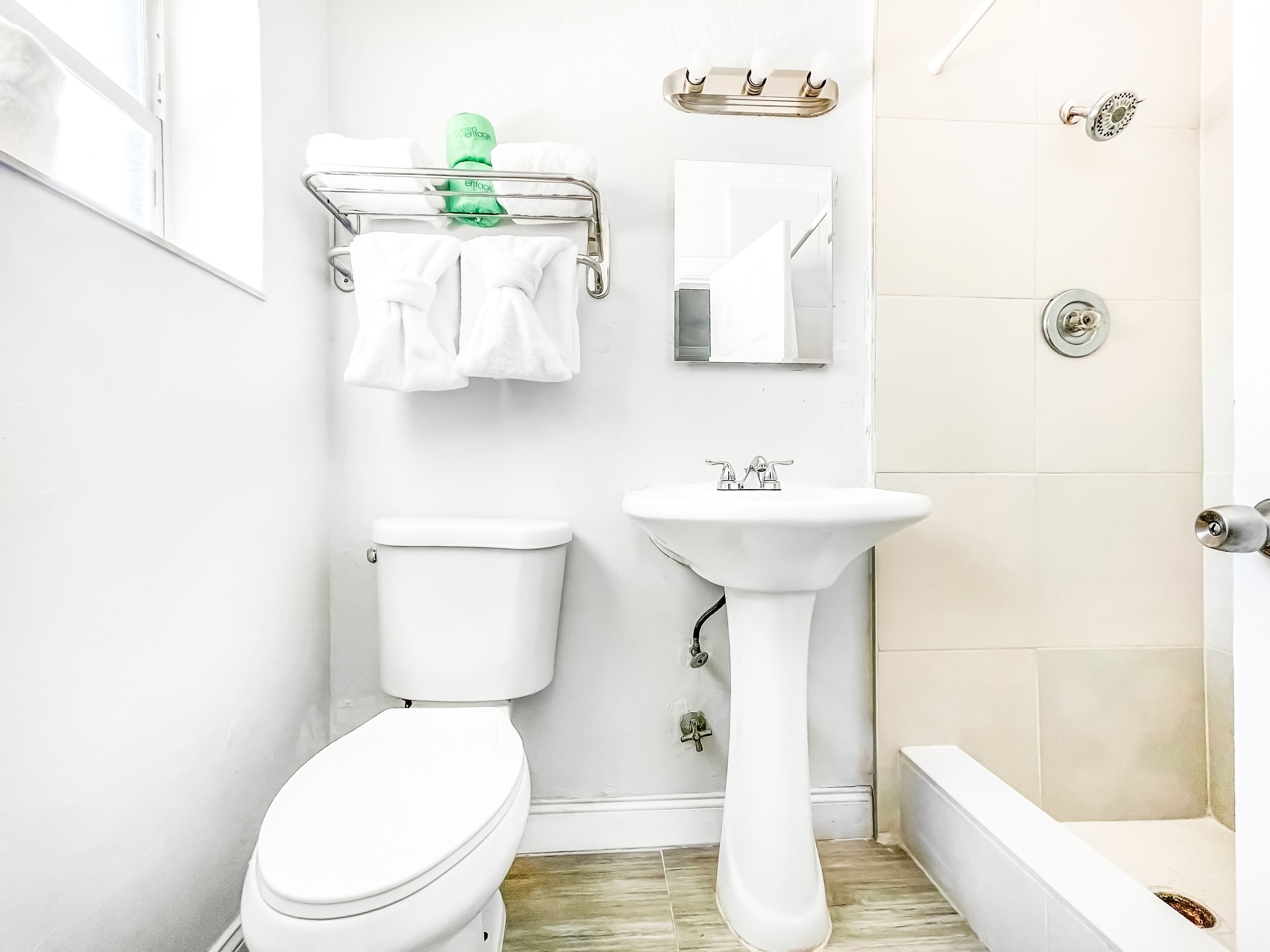 A bathroom with a toilet, sink, and shower.