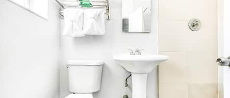 A bathroom with a toilet, sink, and shower.