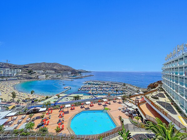 A resort with a large pool, beach area, and ocean view. - Punta del Rey - Adults Only (Mogan)