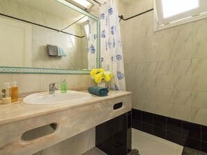 A bathroom with a sink, mirror, and shower area. - Porlamar (Mogan)