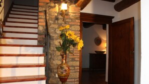 Una escalera con escalones de madera y un jarrón decorativo con girasoles.