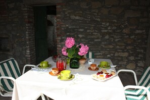 A table set for breakfast with a pitcher, cups, and a plate of pastries.