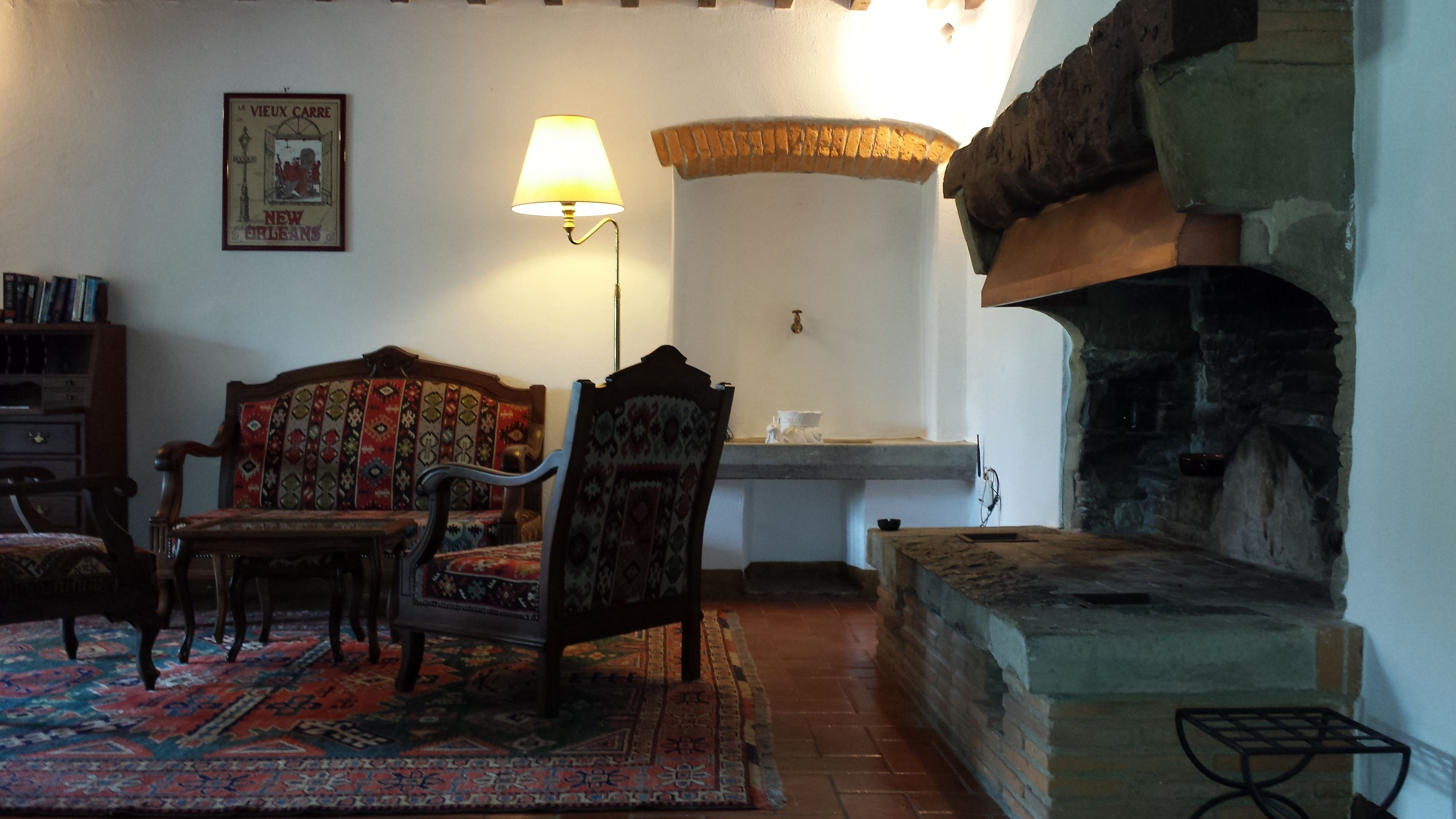 Una sala de estar acogedora con un sofá estampado, una mesa de centro de madera y una chimenea tradicional.