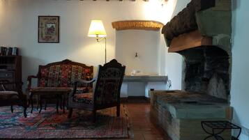 Una sala de estar acogedora con un sofá estampado, una mesa de centro de madera y una chimenea tradicional.