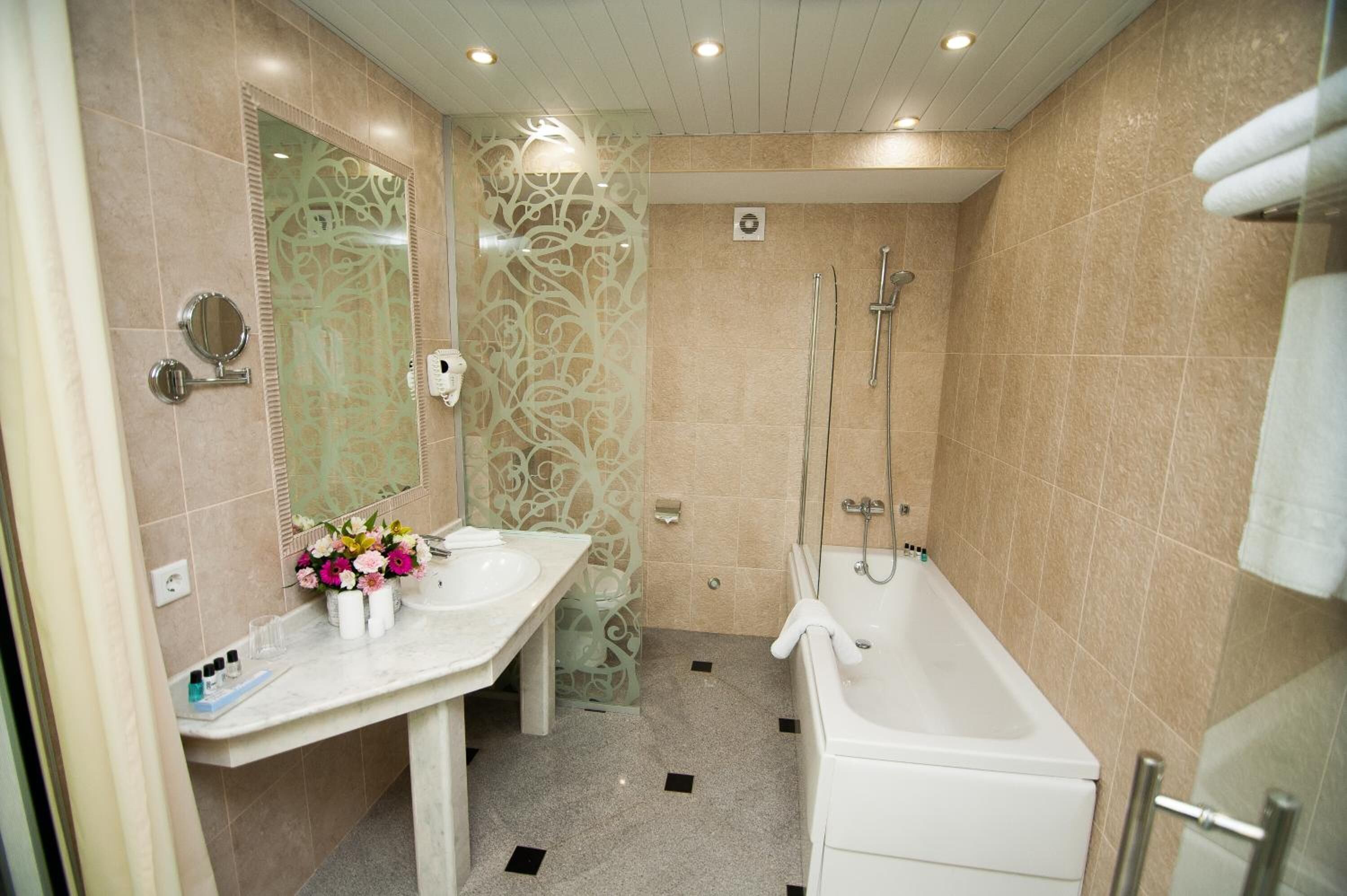 A modern bathroom with a white vanity, a large mirror, a shower area, and a bathtub.