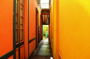 A narrow hallway with orange walls and a wooden floor. - Gran Hotel (Lima)