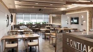Un interior de restaurante moderno con mesas y sillas de madera, ventanas amplias y una pared de ladrillo decorativa.