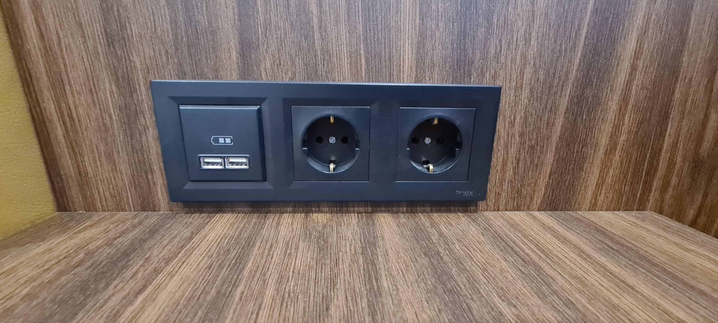 A wall-mounted electrical outlet with two USB ports and two standard electrical sockets.