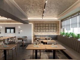 Een modern restaurant met houten tafels en banken, een bakstenen muur en een plafond met zichtbare balken.