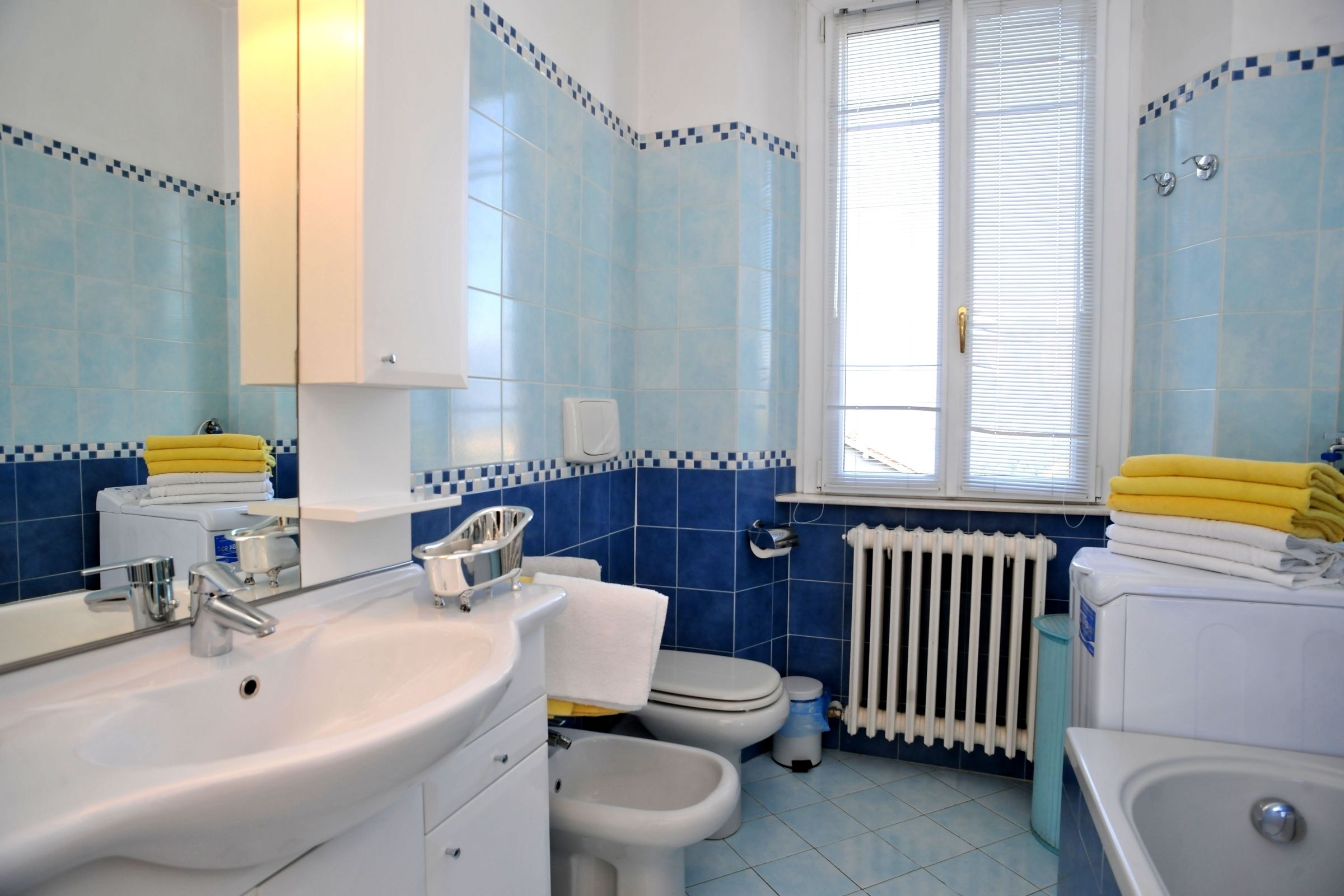 A bathroom with a sink, toilet, bidet, and bathtub.