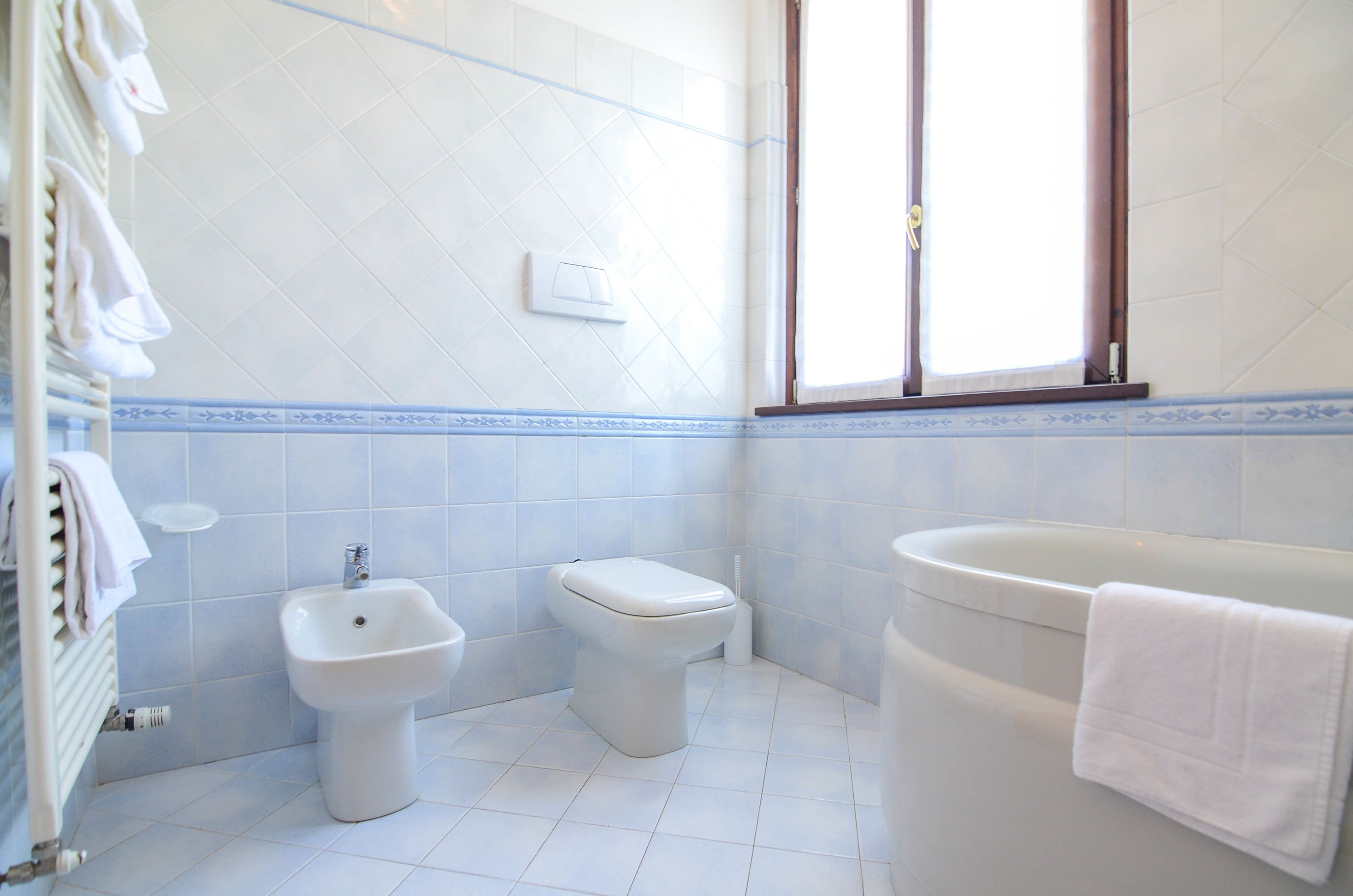 Un baño con bidé, inodoro y bañera.