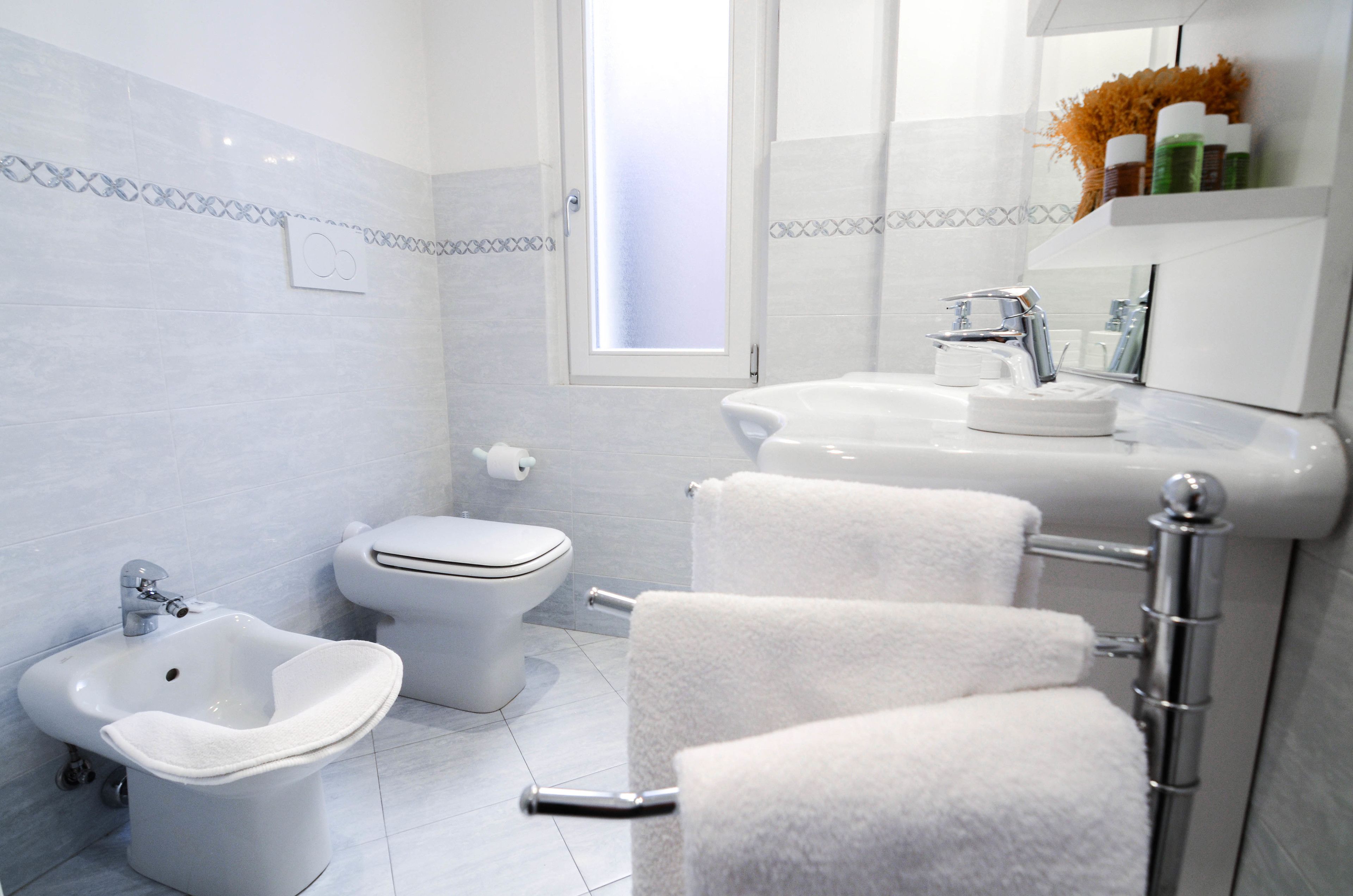 Un baño moderno con bidé, inodoro y lavamanos.