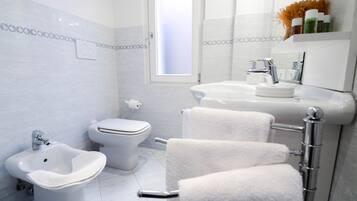 Un baño moderno con bidé, inodoro y lavamanos.