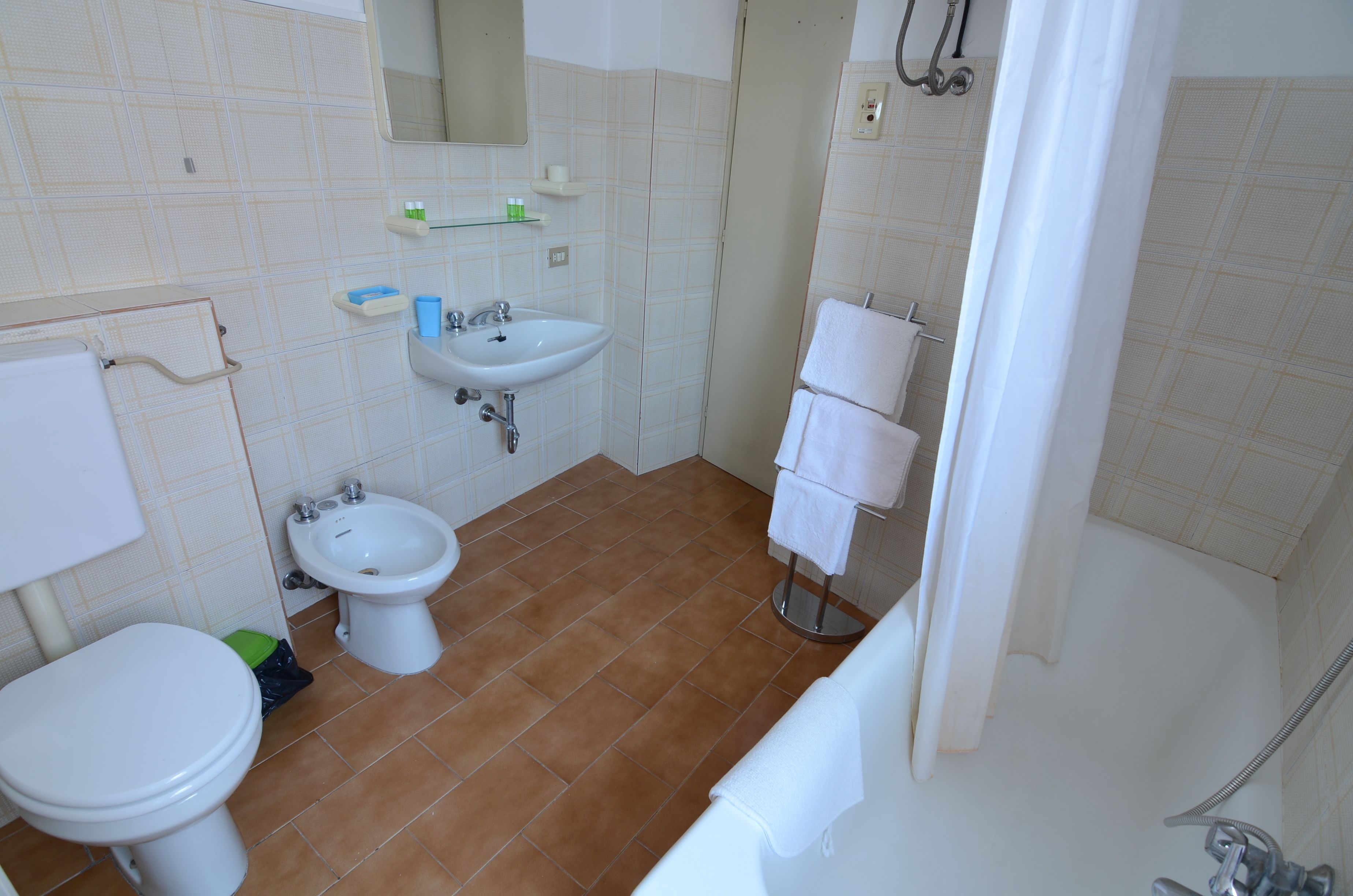 Baño con inodoro, bidé, lavamanos y ducha.