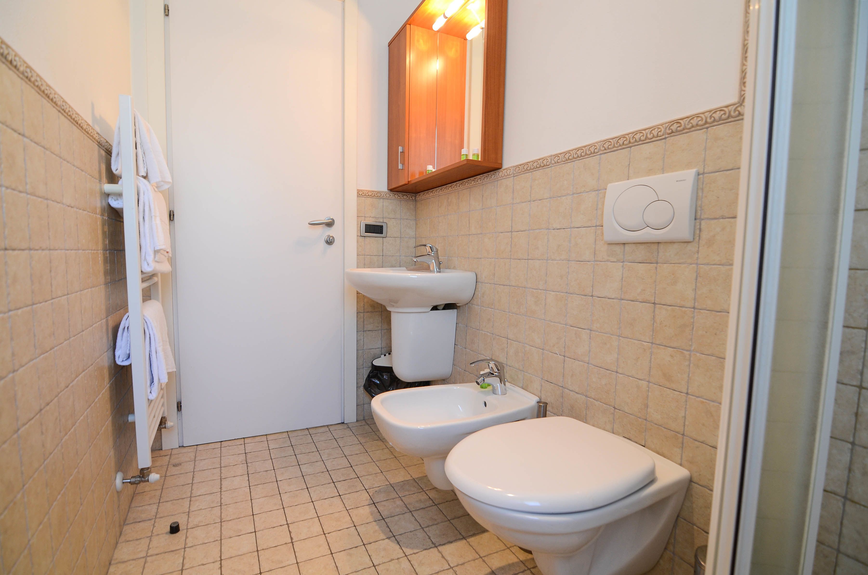 Un baño con inodoro, lavabo, toallero y bidé.