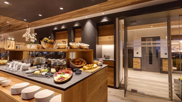 Un bufé de desayuno moderno con diversos alimentos y utensilios.