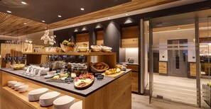 A modern breakfast buffet with various food items and utensils. - Arcade Apartments (Saas-Fee)