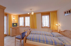 A bedroom with two beds, a desk, and a chair. - Arcade Apartments (Saas-Fee)