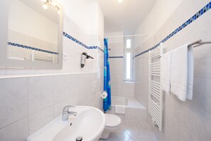 Ein modernes Badezimmer mit Waschbecken, Toilette und Dusche.