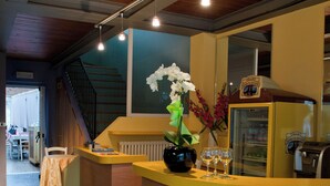A reception area with a wooden counter, a staircase, and a refrigerator.
