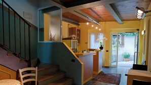 A multi-level interior with a staircase, a kitchen area, and a dining space.