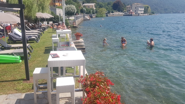 A lakeside setting with outdoor seating and a view of the water.