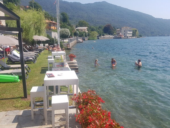 Praia particular, espreguiçadeiras, guarda-sóis, toalhas de praia