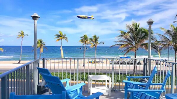 Una playa cerca, arena blanca, sombrillas, toallas de playa