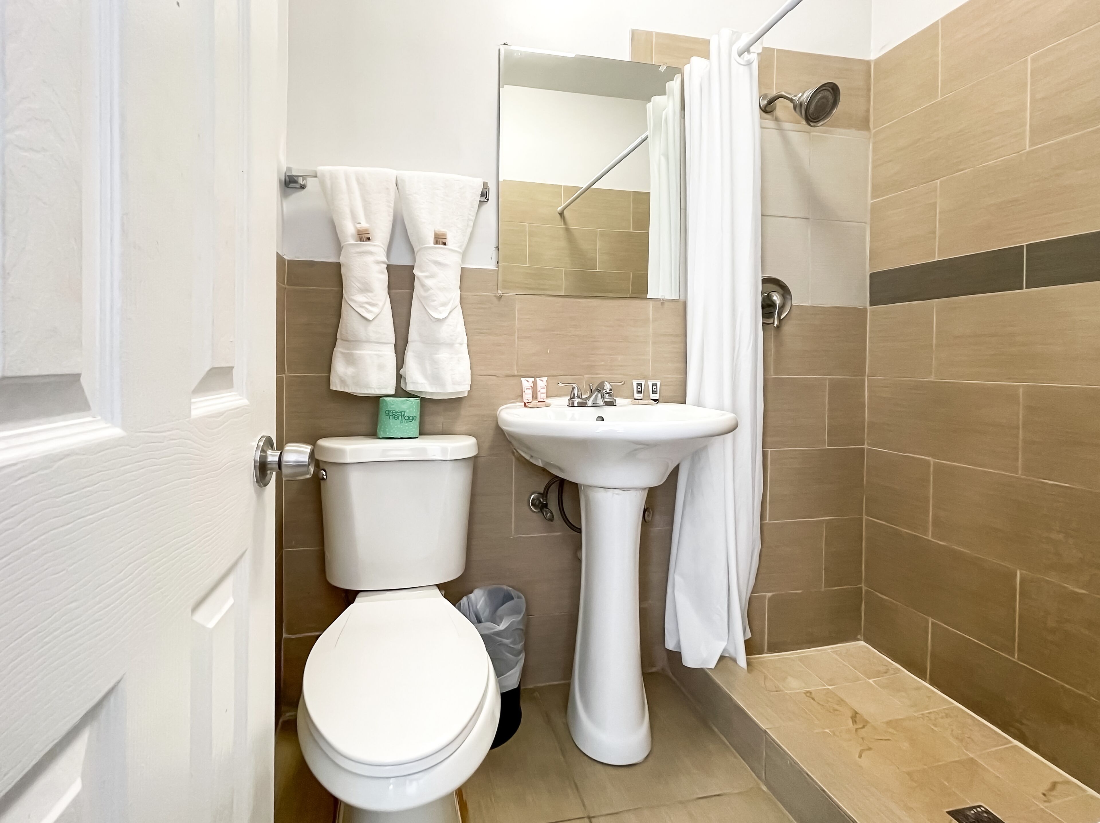 A bathroom with a toilet, sink, and shower.