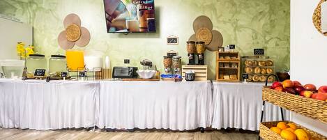 Una barra de desayuno con diversos alimentos y un televisor mostrando un mensaje.