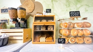A bakery display with various baked goods and a coffee machine. - Hollywood Beach Seagull (Hollywood)